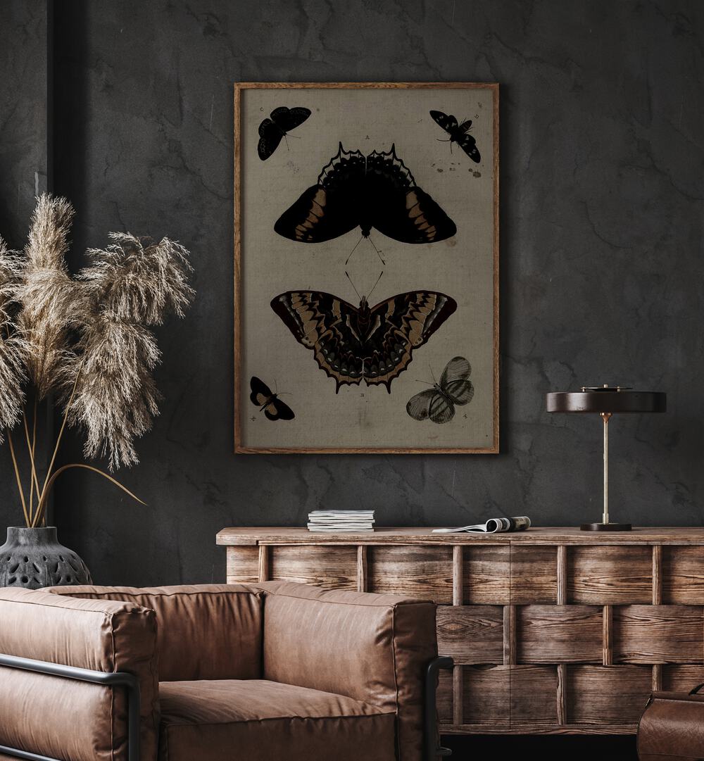 Gothic Flutter Wings Of Darkness And Intrigue Gothic Art Prints in Oak Wood Plain Frame hanging on wall above brown chair beside plant.