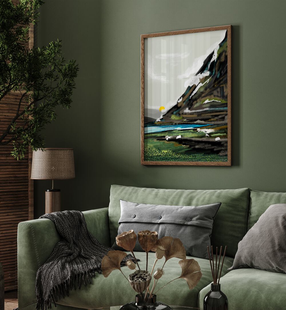 Graze By Uma Gokhale Landscape Paintings in Oak Wood Plain Frame on a wall behind a green sofa