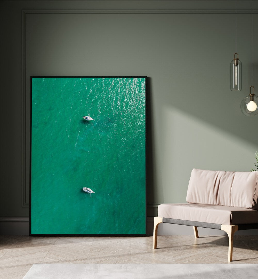 Green Jewel Tropics Beach Prints Coastal Wall Art in Black Plain Frame placed on the floor beside a sofa