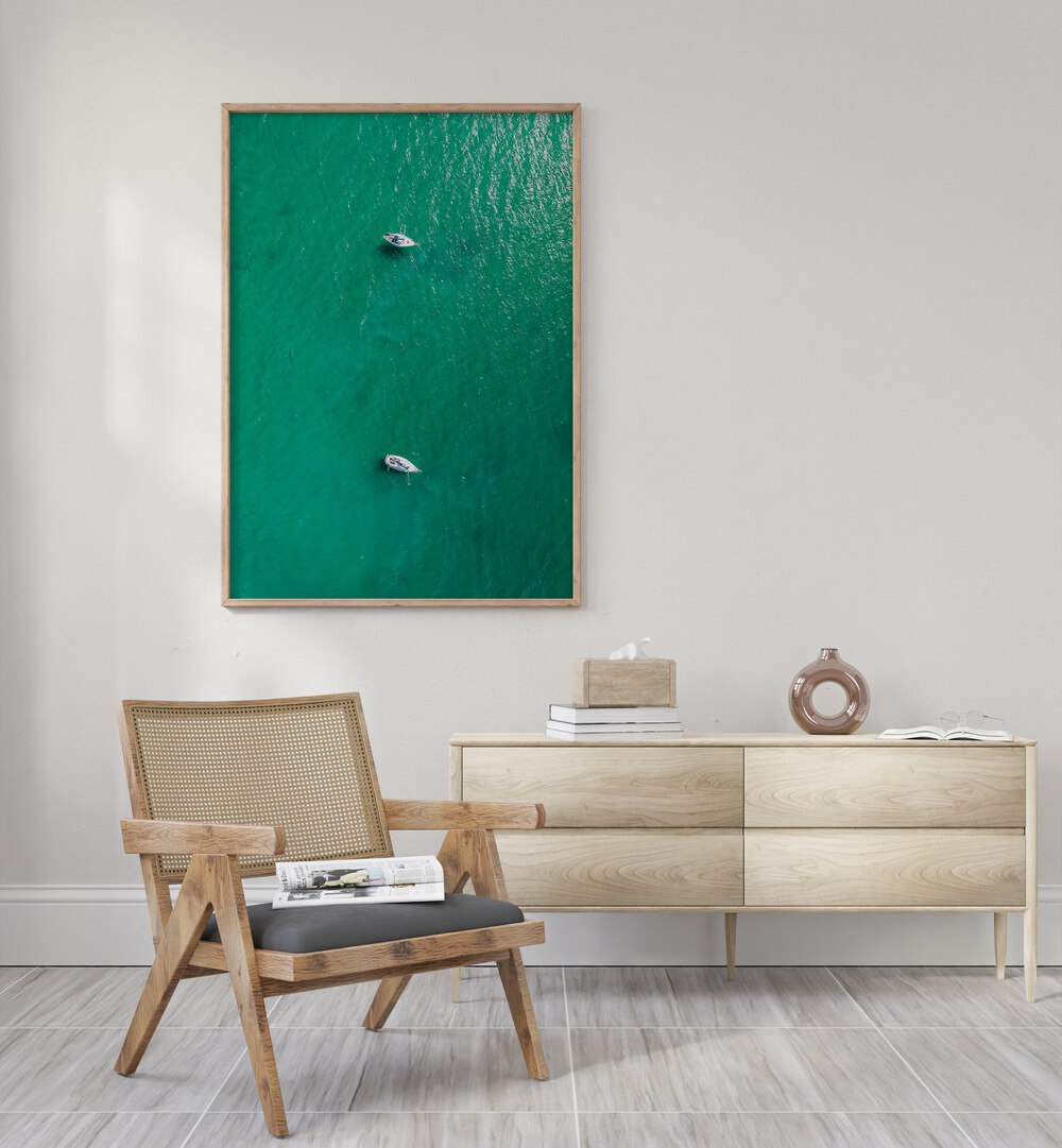 Green Jewel Tropics Beach Prints Coastal Wall Art in Oak Wood Plain Frame placed on a white wall behind a console table and a chair