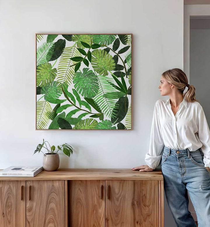 GREEN TROPICAL WATERCOLOR LEAVES , FLORAL FLOWER PAINTINGS framed botanical watercolor print of mixed tropical leaves on a living room wall