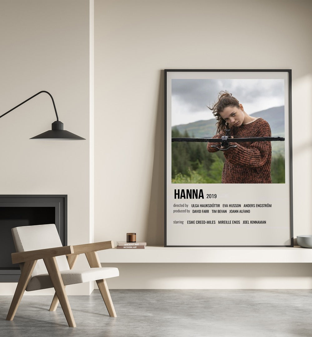 HANNA 2019 MOVIE POSTERS in Black Plain Frame placed on wall beside chair and lamp