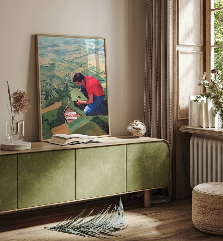 Hide And Seek Surreal Art Painting Artwork in plain oakwood frame on a console table beside a window