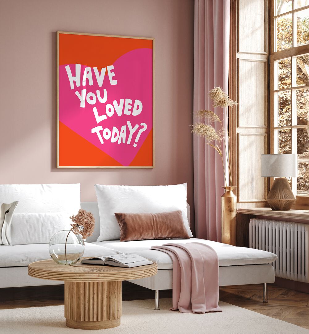 Have You Loved Today by Athene Fritsch Quotes and Typography Posters in Oak Wood Plain Frame placed on a pink wall beside a window and behind a sofa for living room