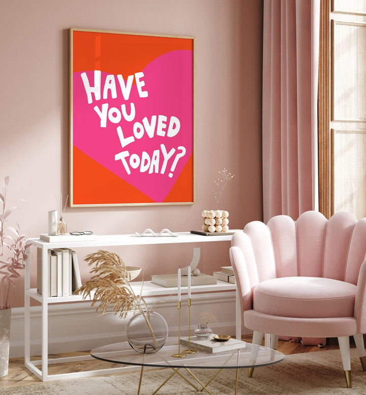 Have You Loved Today by Athene Fritsch Quotes and Typography Posters in Oak Wood Plain Frame placed on a pink wall beside a window and behind a table