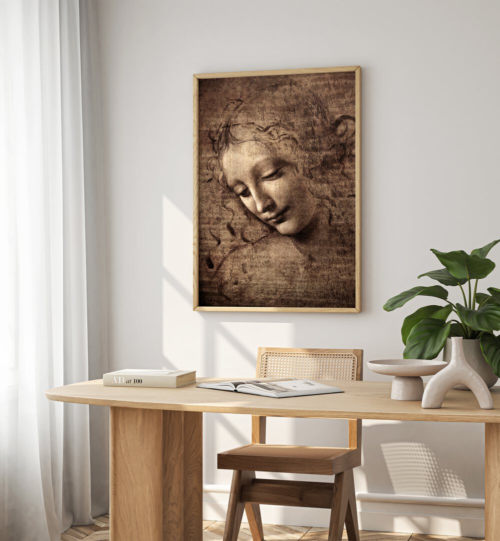 Head Of Women Vintage Paintings in Oak Wood Plain Frame placed on a white wall behind a study table