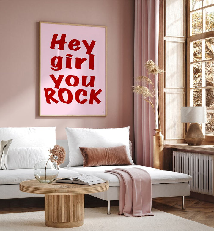 Hey Girl You Rock by Anne-marie Volfova Quotes and Typography Posters in Oak Wood Plain Frame placed on a living room wall behind a sofa and beside a window