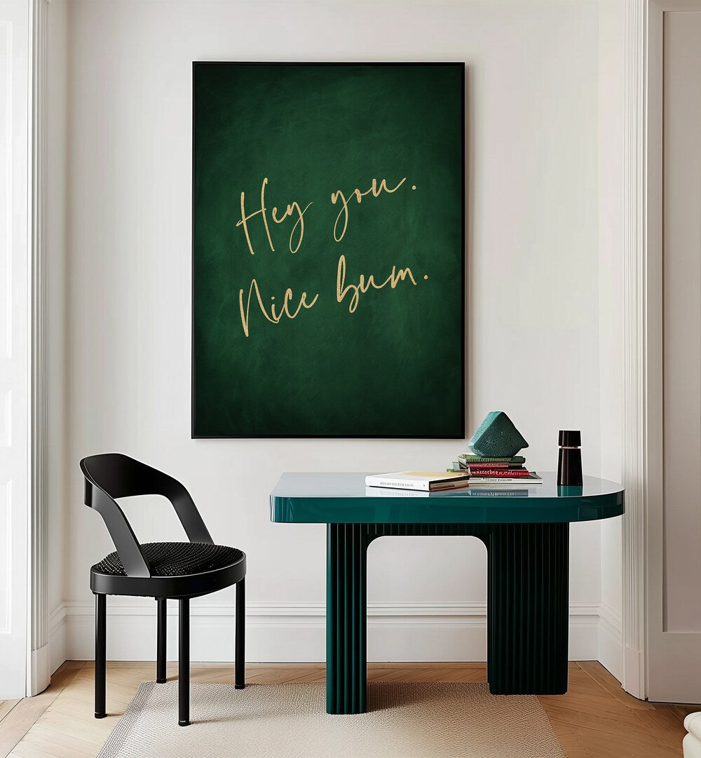 Hey You Nice Bum Emerald Green By Aureous Quotes And Typography Posters in Black Plain Frame placed on a Cream Colored Wall near a Table in a Workspace in the Drawing Room