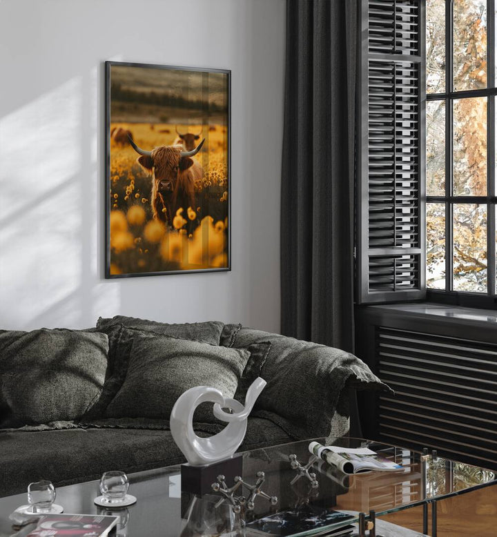 Highland Cows In Flower Field Wildlife Art Prints in Black Plain Frame placed on a White Colored Wall near a Dark Grey Sofa