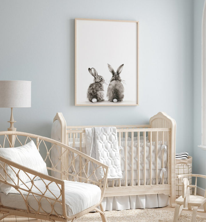 Hoppy Duo Kids Room Paintings Kids Room Wall Art in Oak Wood Plain Frame placed on a wall in a kids room behind an infant's bed