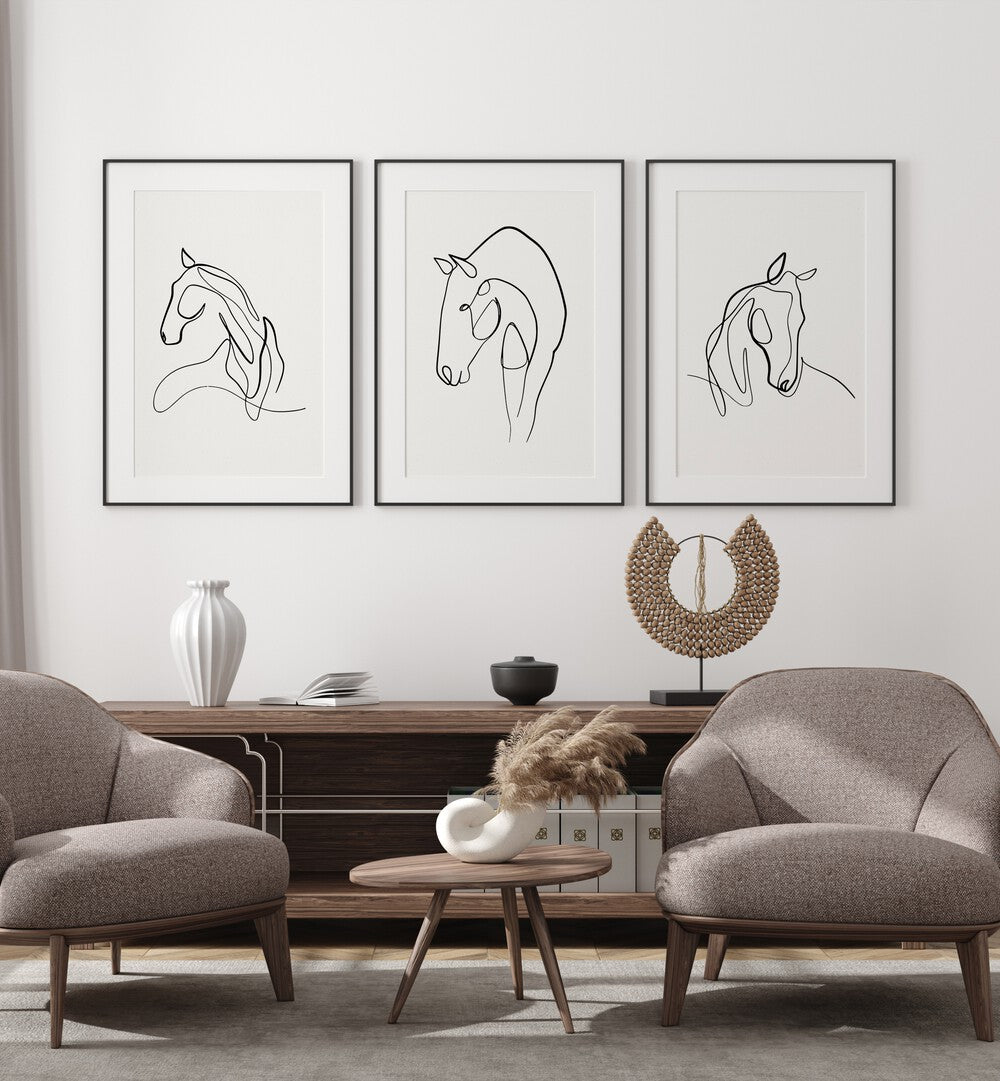 Horses Line Art Set Set Of 3 Paintings in Black Frame With Mount placed on the white wall behind a console table