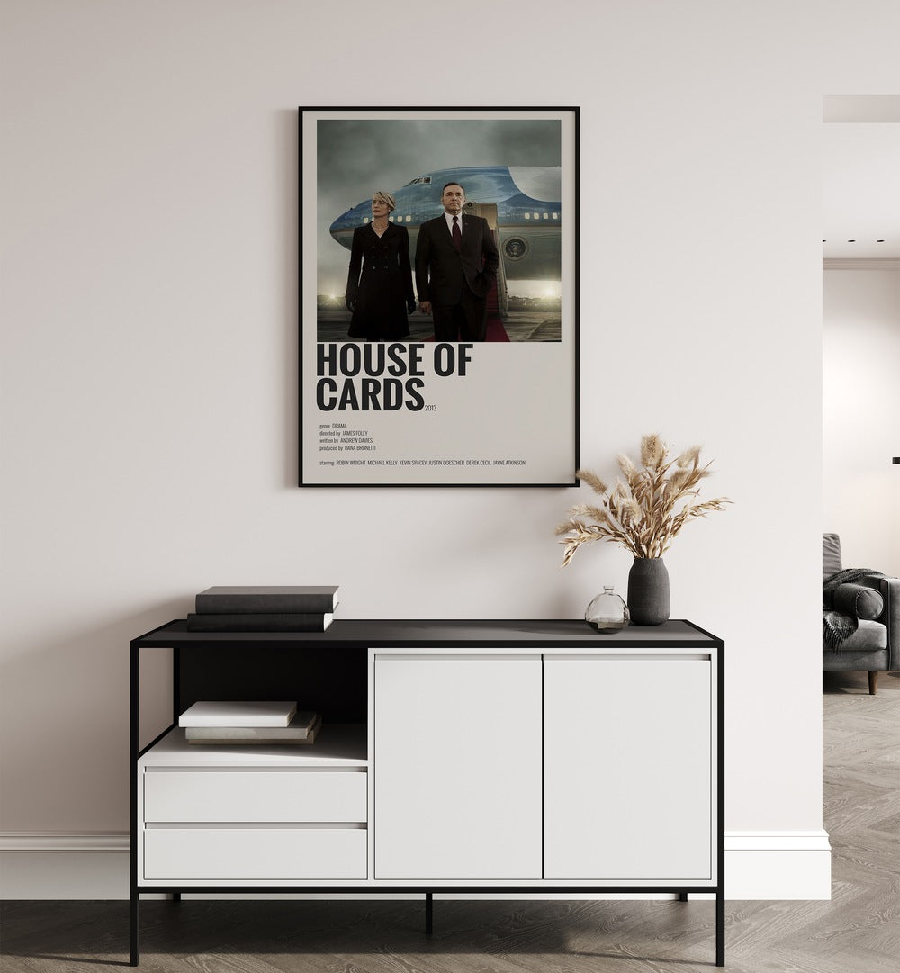 House Of Cards Movie Posters in Black Plain Frame placed on a white wall behind a black and white table