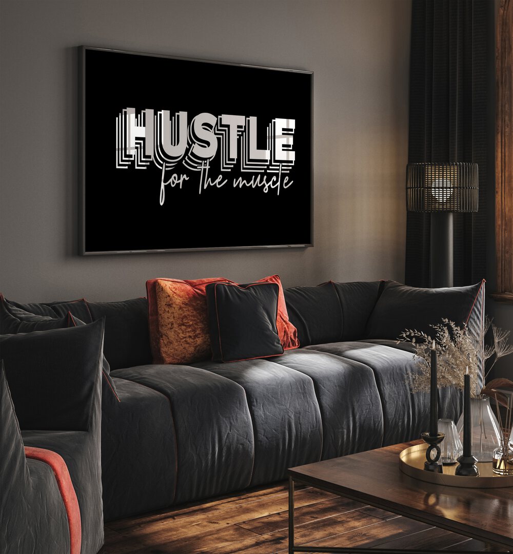 Hustle for the Muscle Quotes and Typography Posters in Black Plain Frame placed on a wall in living room behind a sofa