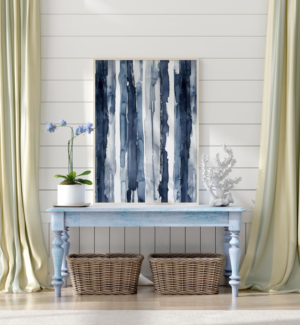 Indigo Waves Beach Prints Coastal Wall Art in White Plain Frame placed on a blue table beside a plant and a showpiece