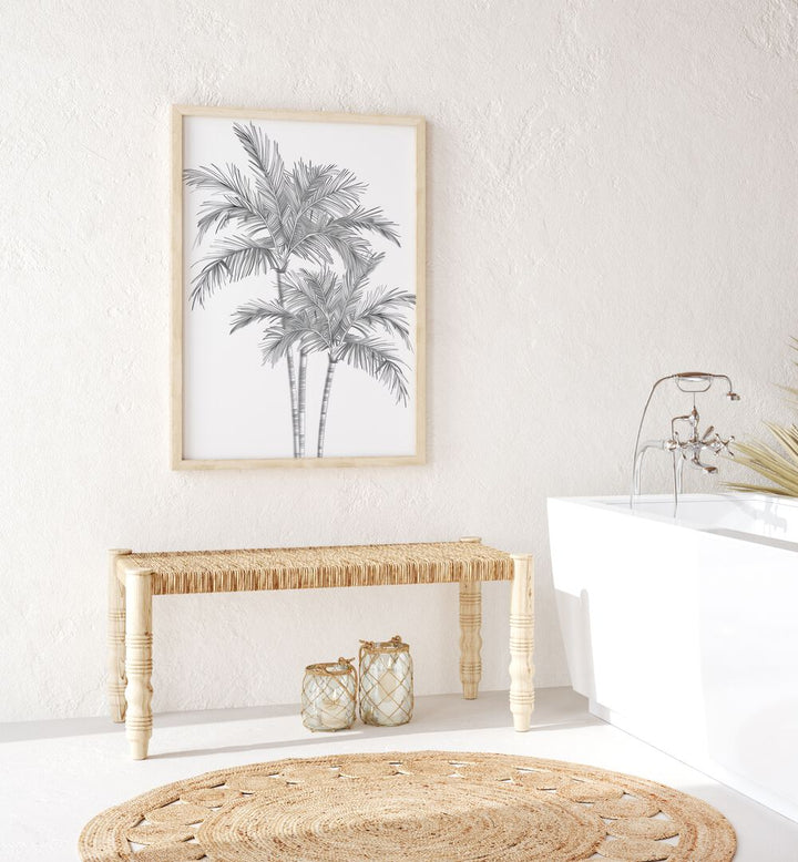 Ink Palm Promenade Beach Prints Coastal Wall Art in Oak Wood Plain Frame placed on a white wall behind table and beside a bathtub