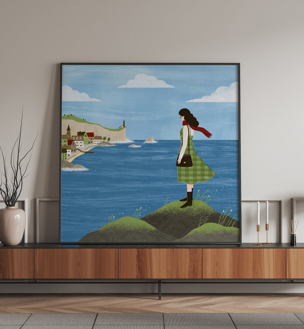 Irish Seaside By Julia Leister Women Illustration Paintings in Black Plain Frame placed on a console table beside a plant and candle stand