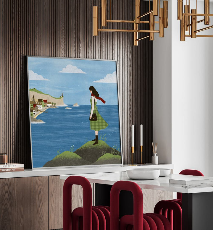 Irish Seaside By Julia Leister Women Illustration Paintings in Black Plain Frame placed on a counter behind a dining table