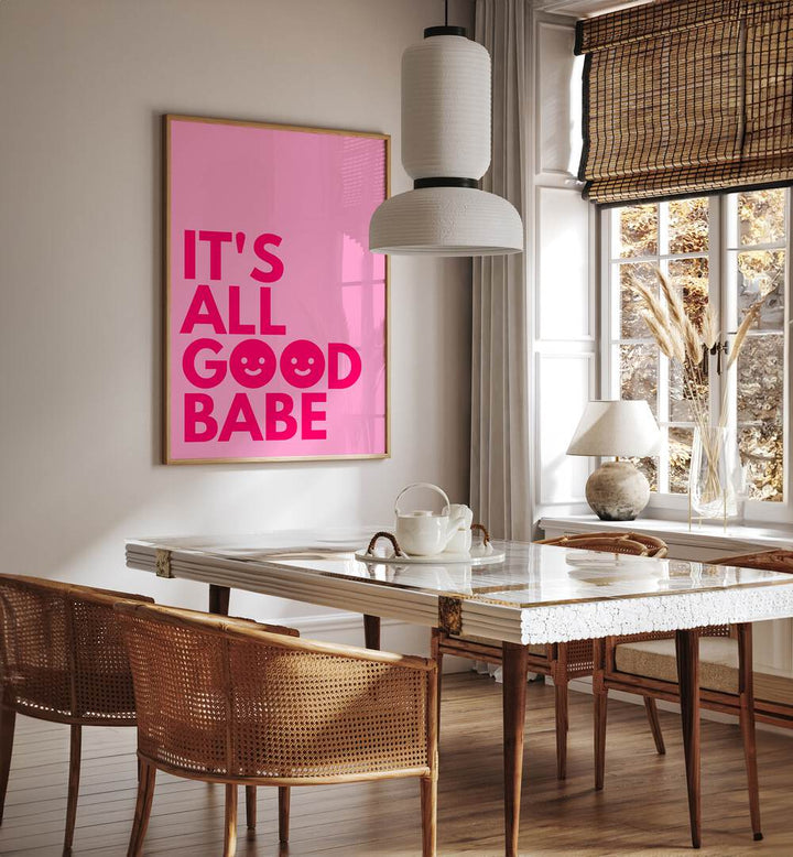 Its All Good Babe by Athene Fritsch Quotes and Typography Posters in Oak Wood Plain Frame placed on a wall in a dining room area beside a window and behind a dining table