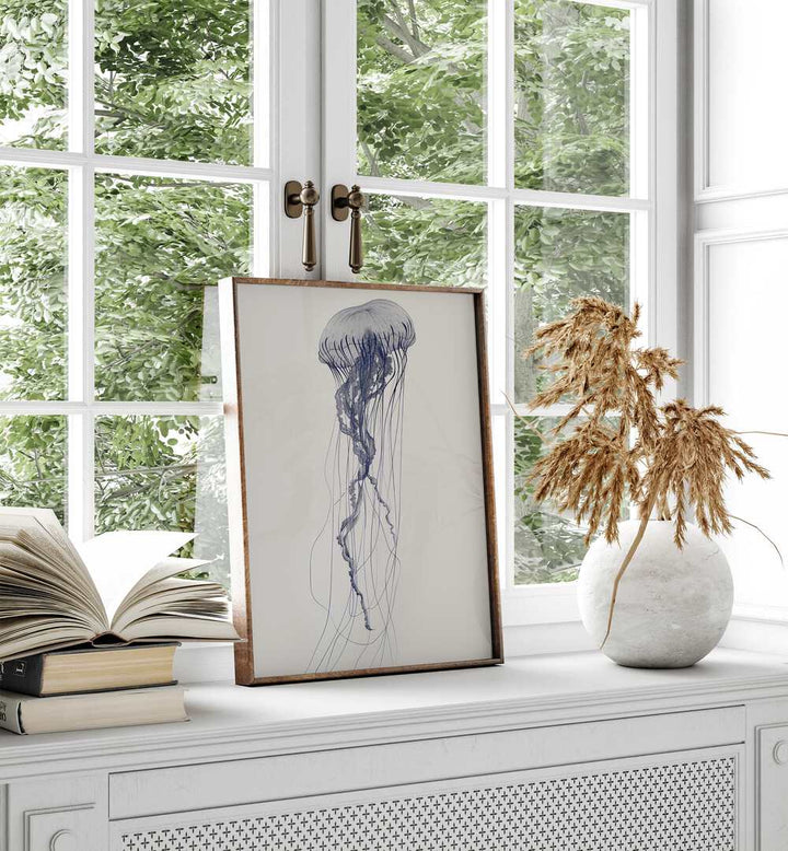 Jelly O Beach Prints Coastal Wall Art in Oak Wood Plain Frame placed on a window beside books