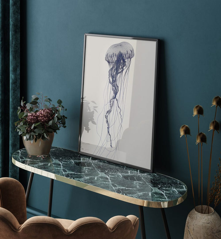 Jelly O Beach Prints Coastal Wall Art in Black Plain Frame placed on a green table beside a flower pot