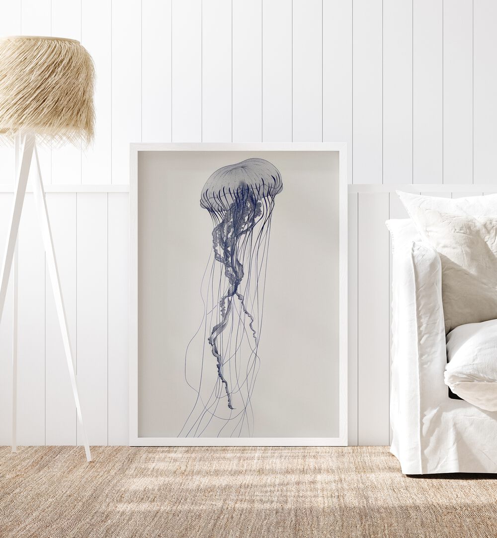 Jelly O Beach Prints Coastal Wall Art in White Plain Frame placed on a floor beside a sofa and a lamp