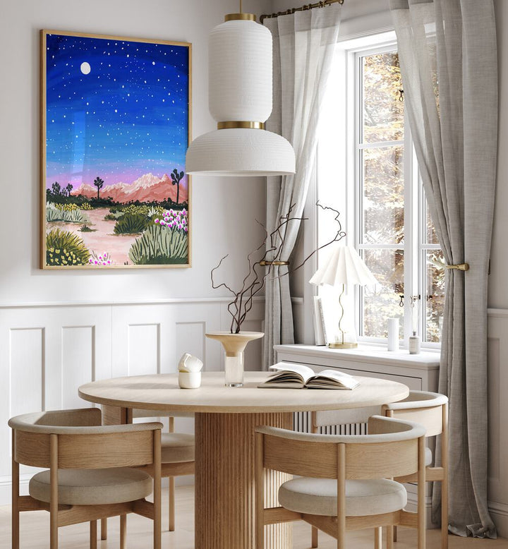 Joshua Tree By Sarah Gesek Landscape Art Prints in Oak Wood Plain Frame placed on a wall behind a dining table and beside a window for dining area