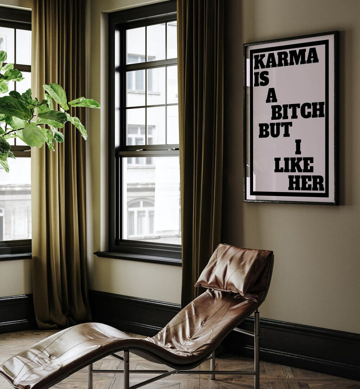 Karma is a Bitch by Athene Fritsch Quotes and Typography Posters in Black Plain Frame placed on a living room wall behind a chair and beside a window