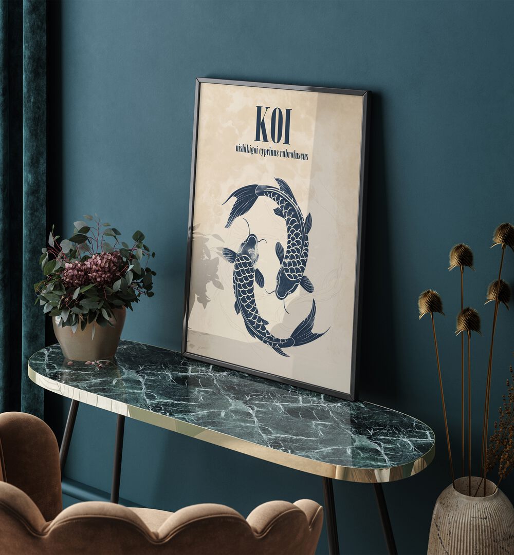 Koi Beach Prints Coastal Wall Art in Black Plain Frame placed on a green table beside a plant