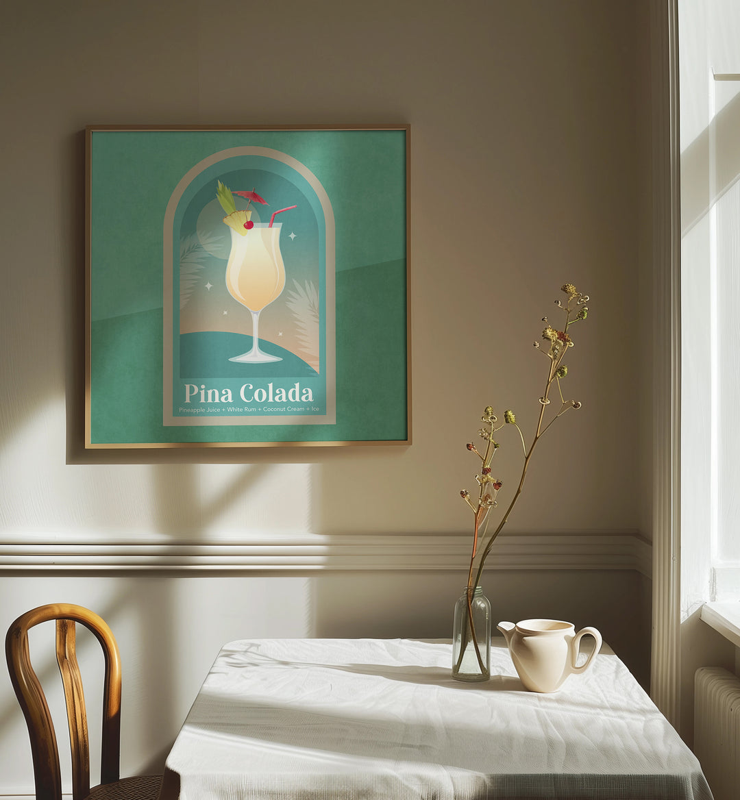 Kokteyl Pina Colada By Emel Tunaboylu Bar Posters Bar Art Prints in Oak Wood Plain Frame placed on a Cream Colored Wall near a Coffee Table in the Dining Room