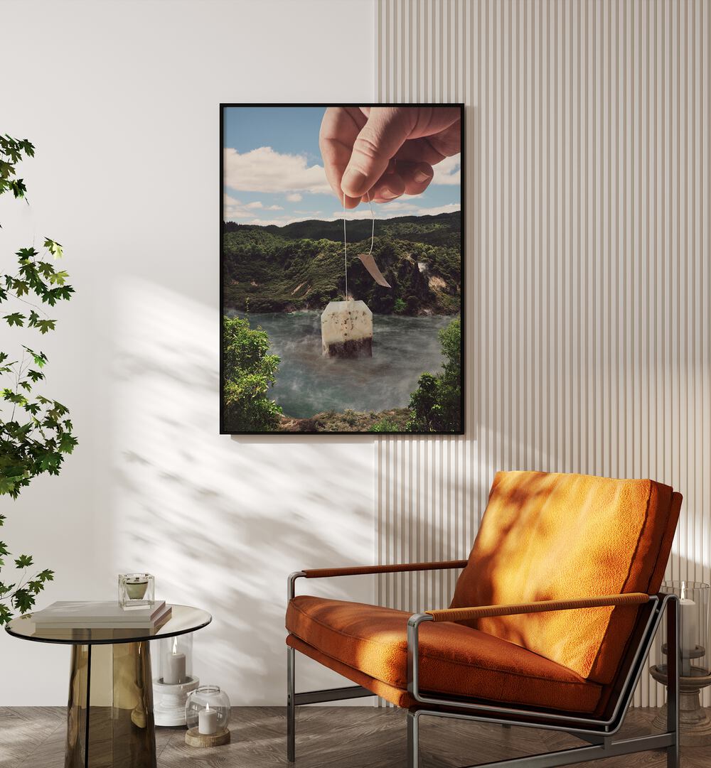 Lake Afternoon Tea-teabag Surreal Art Painting Artwork 
in plain black frame beside an orange sofa.