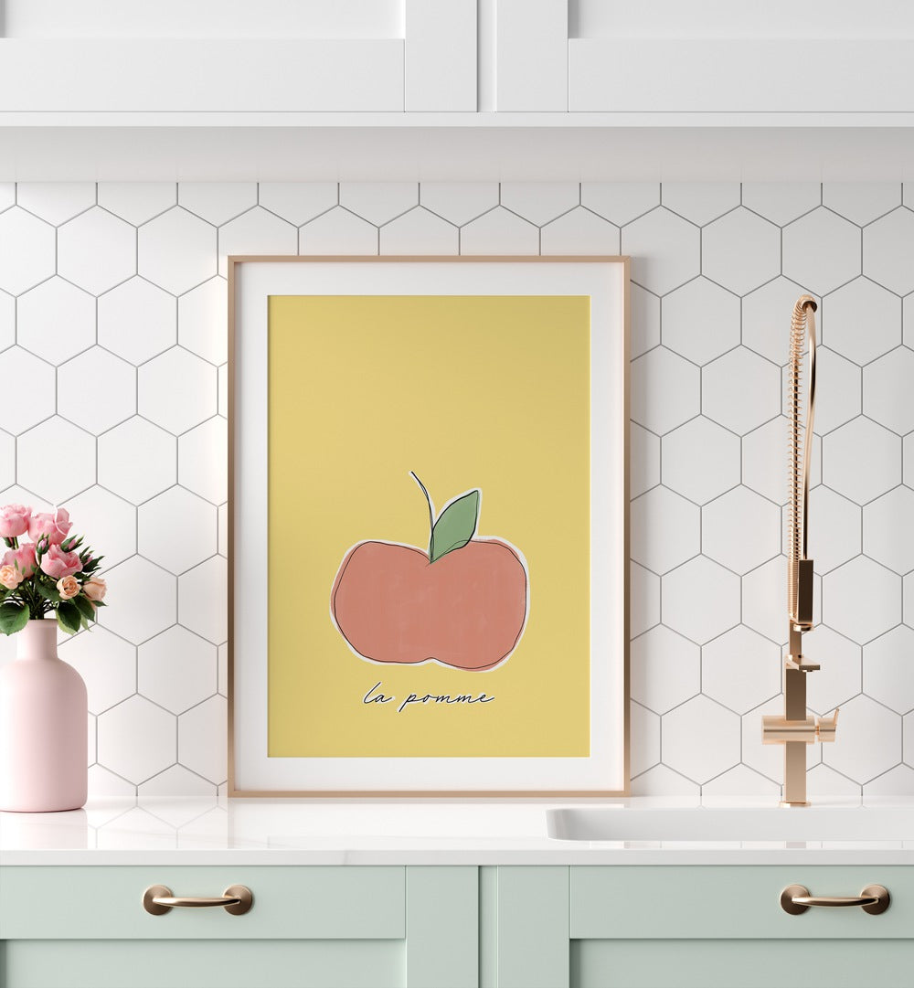 La Pomme by Uplus Me Studio Kitchen Art Prints Kitchen Posters in Oak Wood Frame With Mount placed on a kitchen counter for kitchen area