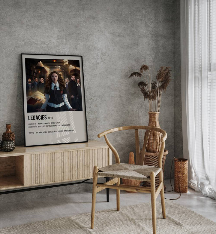 Legacies 2018 Movie Posters in Black Plain Frame placed on a table beside oakwood chair