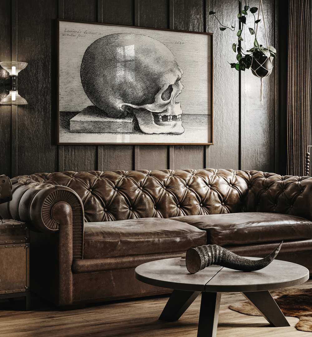 Leonardo Da Vincis Skull In Profile To Right 1645 Vintage Paintings in Dark Oakwood Plain Frame placed on a wall behind a brown sofa 