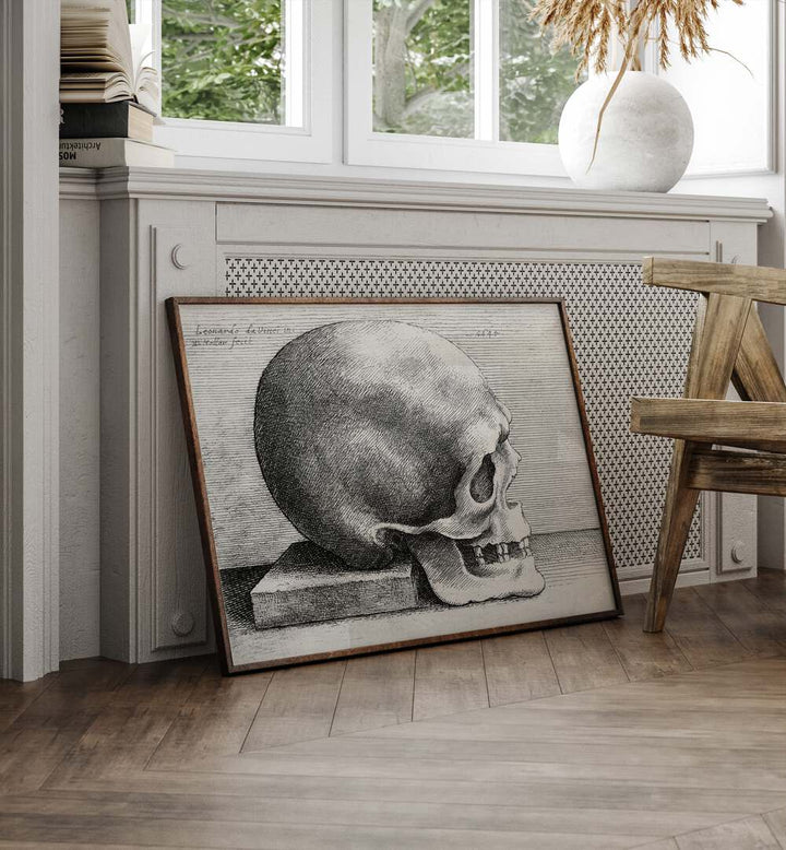 Leonardo Da Vincis Skull In Profile To Right 1645 Vintage Paintings in Oak Wood Plain Frame placed on the floor  beside a chair