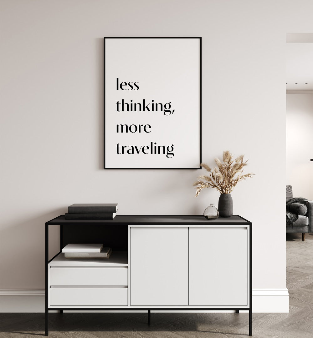 Less Thinking By 1 X Studio Quotes And Typography Posters in Black Plain Frame placed on a White Colored Wall above a Console Table in the Drawing Room