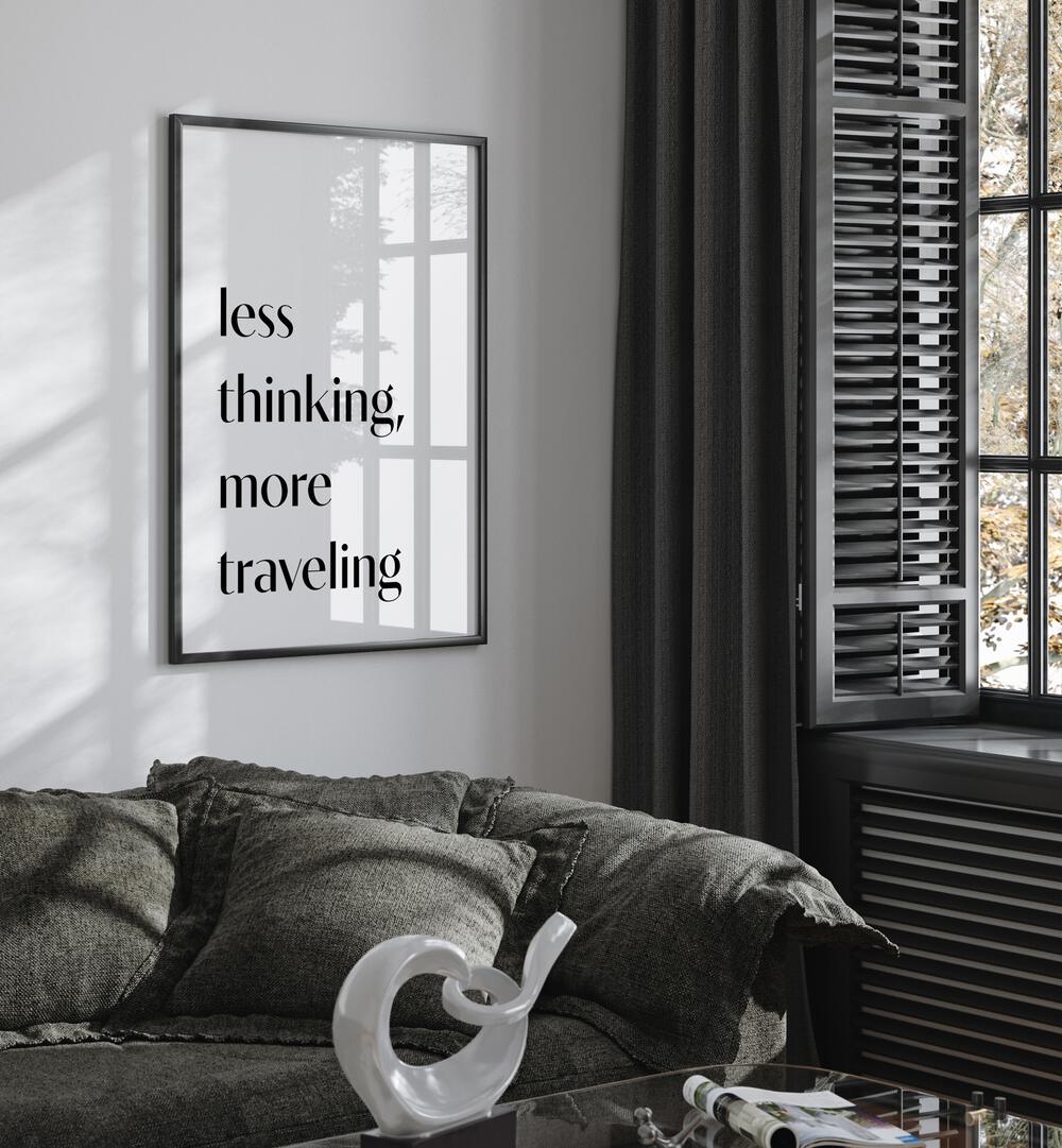 Less Thinking By 1 X Studio Quotes And Typography Posters in Black Plain Frame placed on a White Colored Wall near a Dark Grey Sofa in the Living Room