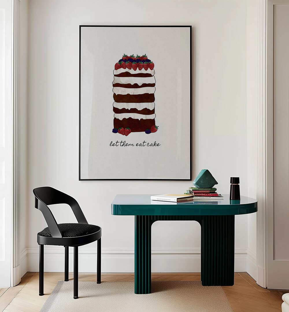 Let Them Eat Cake By Orara Studio Kitchen Posters Kitchen Art Prints in Black Plain Frame placed on a Cream Colored Wall near a Table in a Workspace in the Drawing Room