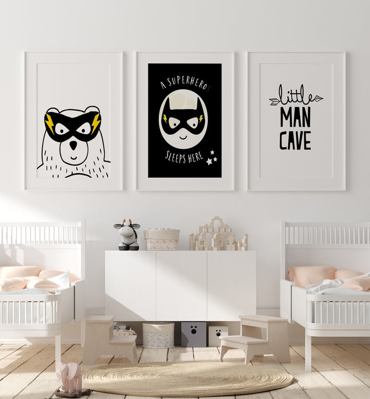 Little Man Cave Set Of 3 Paintings in White Frame With Mount placed on a wall behind an infant's bed for kids room