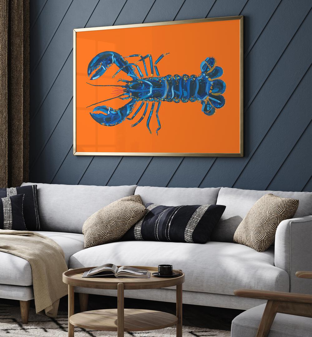 Lobster on Orange by Alice Straker Cafe Art Prints Cafe Posters in Gold Plain Frame placed on a living room wall behind a sofa