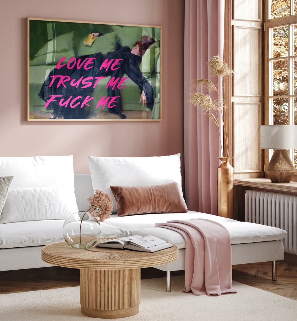 Love Me by the Art Concept Altered Art Prints in Oak Wood Plain Frame placed on a pink wall behind a sofa 