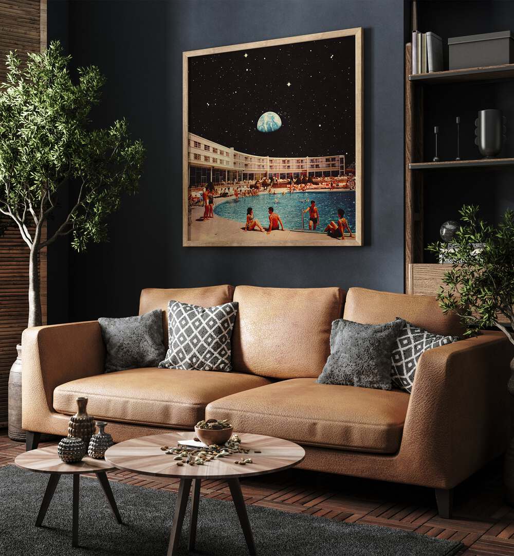 Lunar Pool Surreal Paintings Surreal Art Prints in Oak Wood Plain Frame placed on a Blue Colored Wall near a Brown Sofa in the Living Room