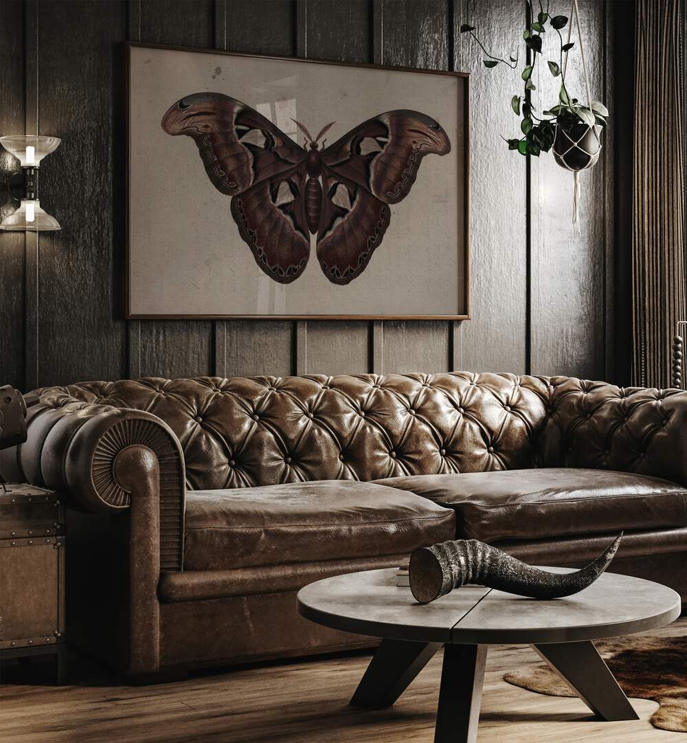 Metamorphosis Embracing The Wings Of Change Gothic Art Prints in Oak Wood Plain Frame hanging on a wall above brown leather couch beside a window