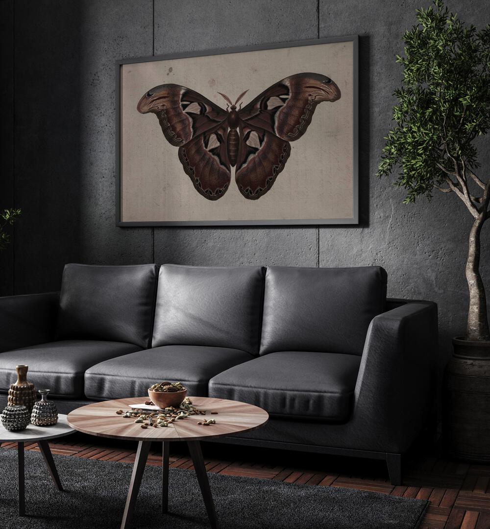 Metamorphosis Embracing The Wings Of Change Gothic Art Prints in Black Plain Frame hanging on a wall above black leather couch beside a plant.