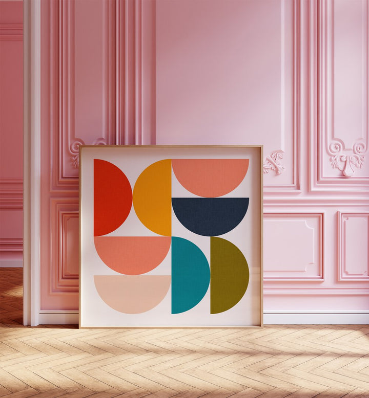 Mid Century Geometric Color Play IV By Ana Rut Bre Abstract Art Abstract Paintings in Oak Wood Plain Frame placed on the floor near a Pink Colored Wall in the Alley Way