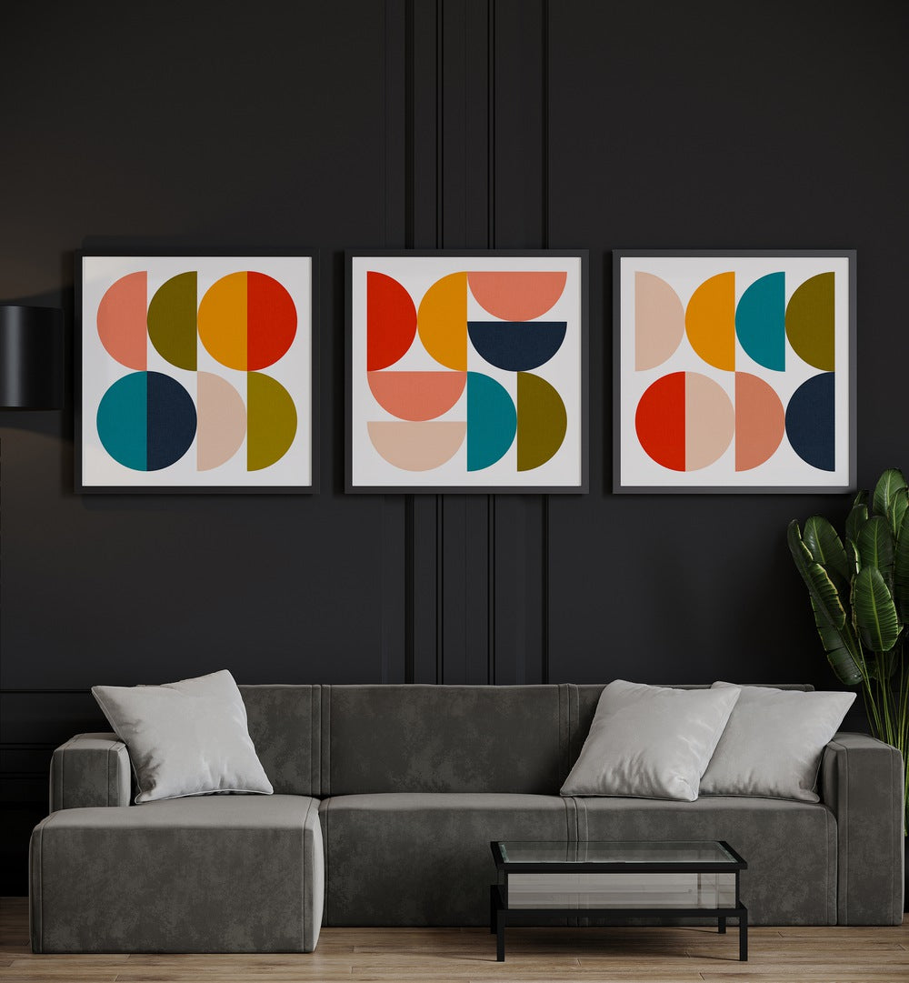 Mid-Century Geometrical Colour Play Set Of 3 Paintings in Black Plain Frame placed on a black wall behind a grey sofa