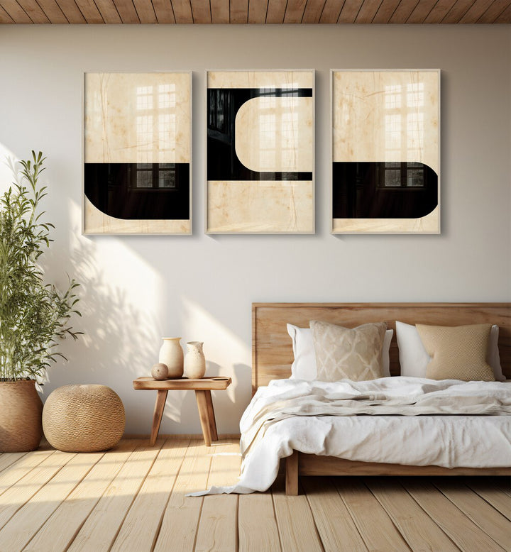 Modern Geometric Set Set Of 3 Paintings in White Plain Frame placed on a bedroom wall behind a bed and beside a plant