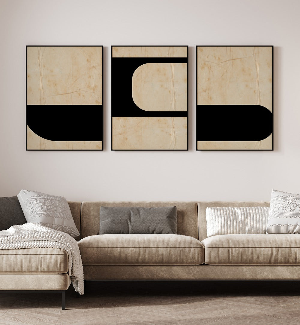 Modern Geometric Set Set Of 3 Paintings in Black Plain Frame placed on a white wall behind a sofa