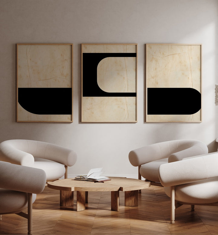 Modern Geometric Set Set Of 3 Paintings in Oak Wood Plain Frame placed on a white wall beside white chairs 