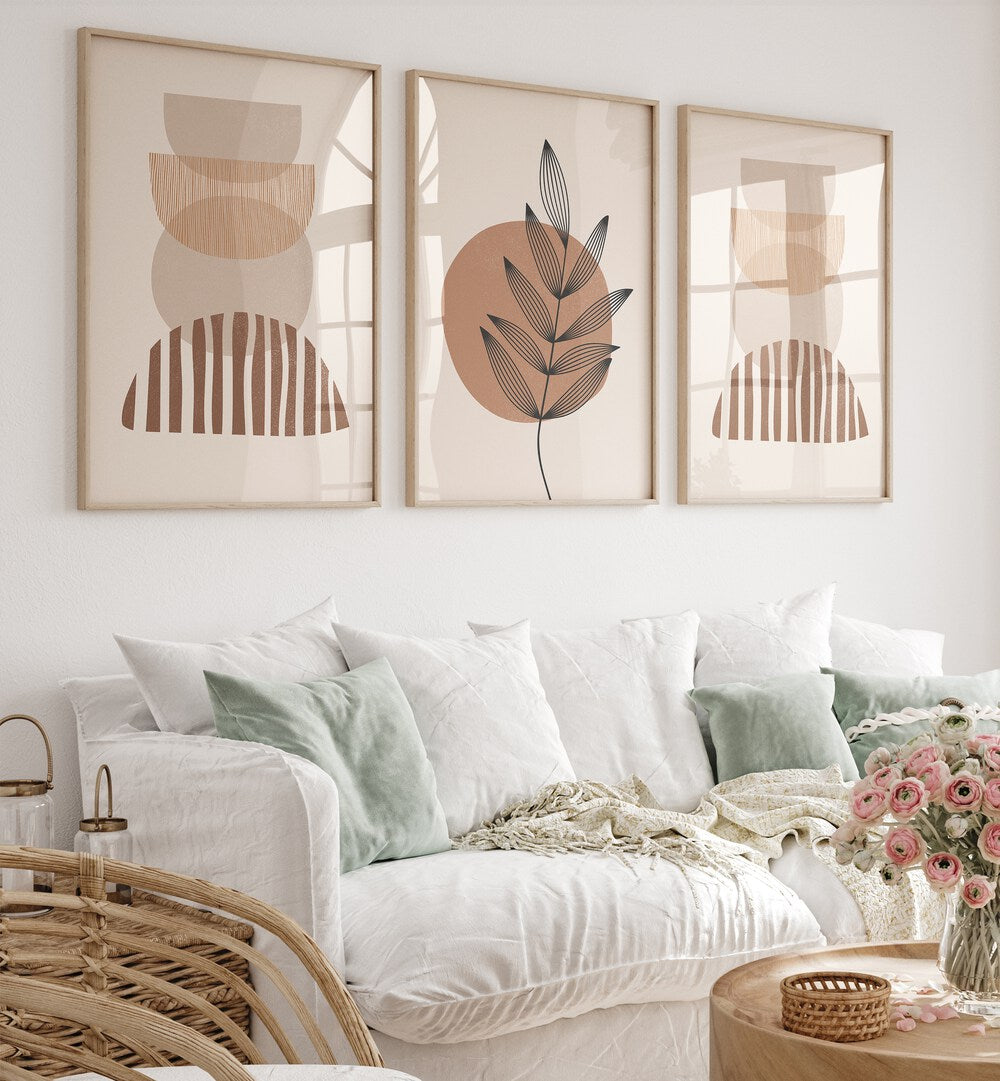 Modern Leaf Geometric Set Set Of 3 Paintings in Oak Wood Plain Frame placed on a white wall behind a sofa for living room