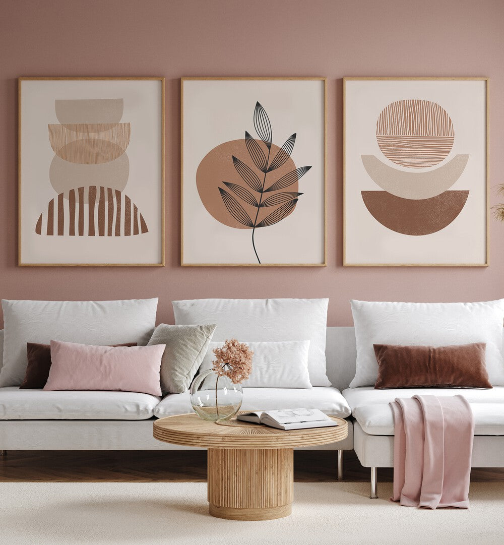 Modern Leaf Geometric Set Set Of 3 Paintings in Oak Wood Plain Frame placed on a wall behind a white sofa for living room